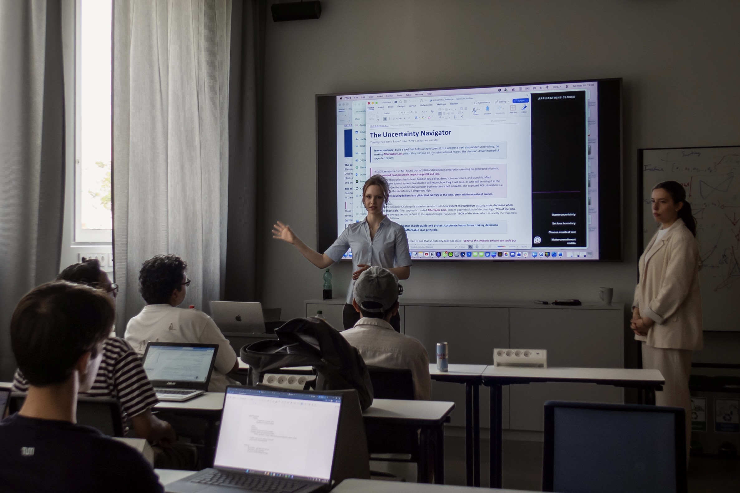 Two Intraprise founders walking hackathon teams through The Uncertainty Navigator challenge brief